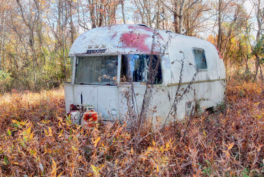 An abandoned RV quietly settled into a field